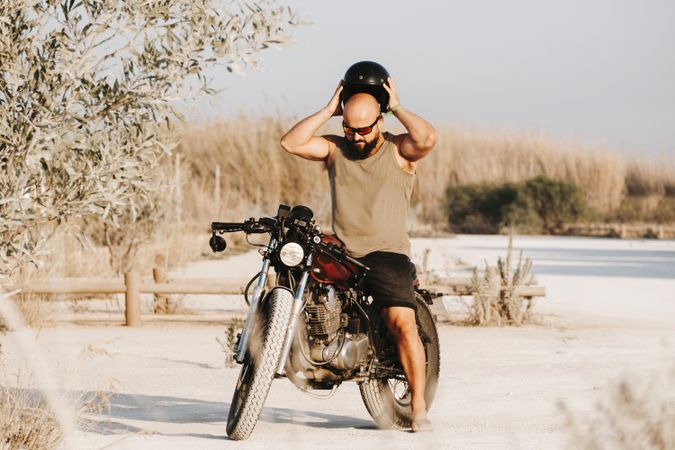 Serious male driving motorcycle in forest