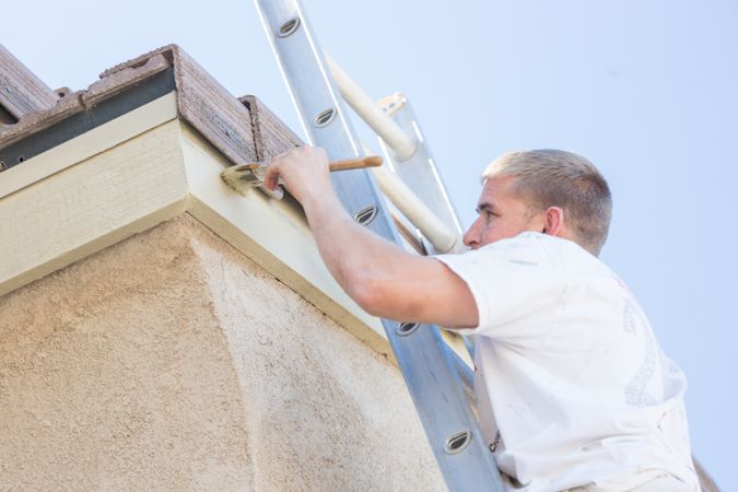 Professional Painter Using A Brush to Paint House Fascia