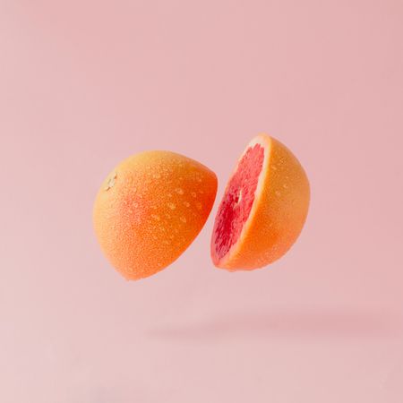 Grapefruit halved on pastel pink background