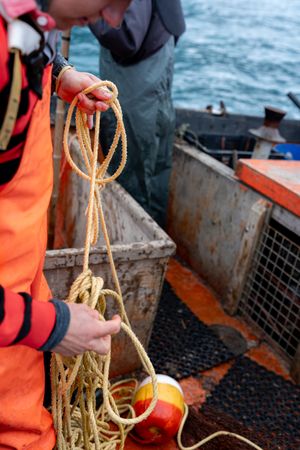 Fisherman working with a rope on a fishing boat