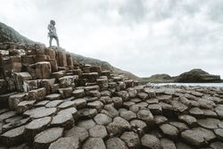 Female standing on cliff and contemplating
