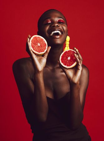 Smiling African woman holding grapefruit