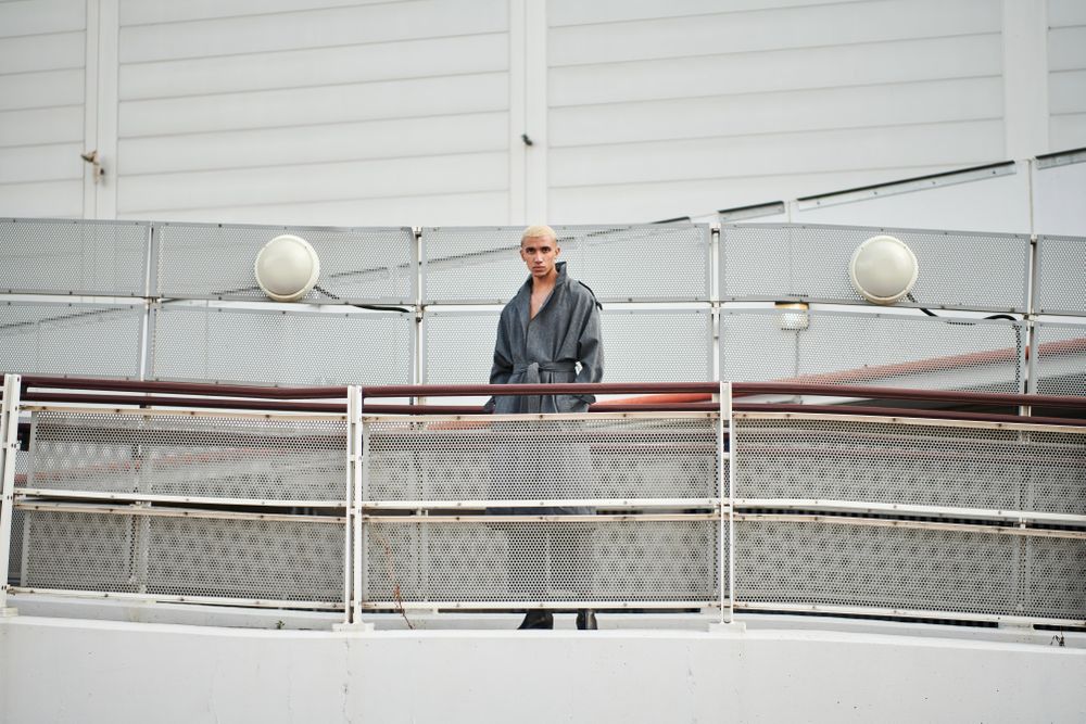 Stylish young man behind fence on ramp