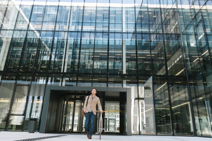 Businessman walking on street with bicycle