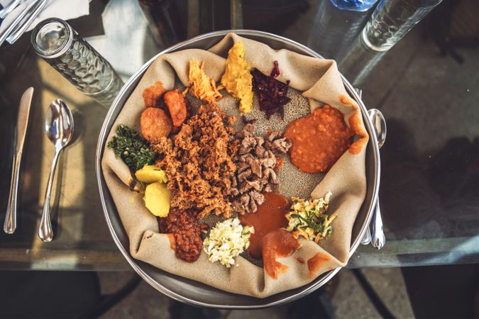 Traditional ethiopian dish of Injera with flatbread and assorted vegetables served on table