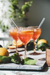 Three Aperol Spritz aperitif alcohol drink in glasses, vertical