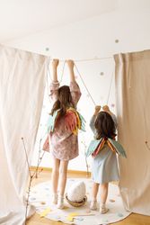 Back view of cute girl angels with raised hands holding rope