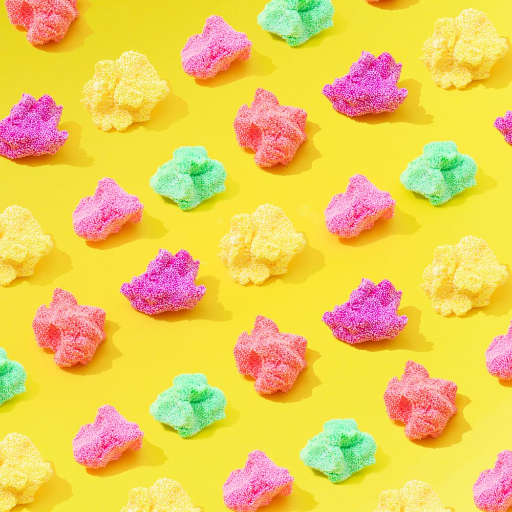 Textured silly putting in different colors in rows on yellow background