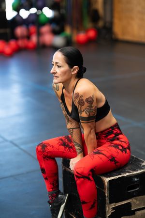 Athletic woman sitting on a box resting after training