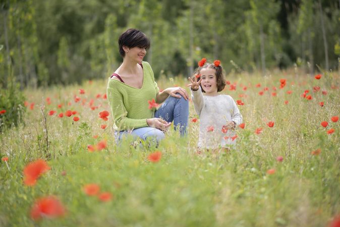 Woman smiling at daughter playing in field