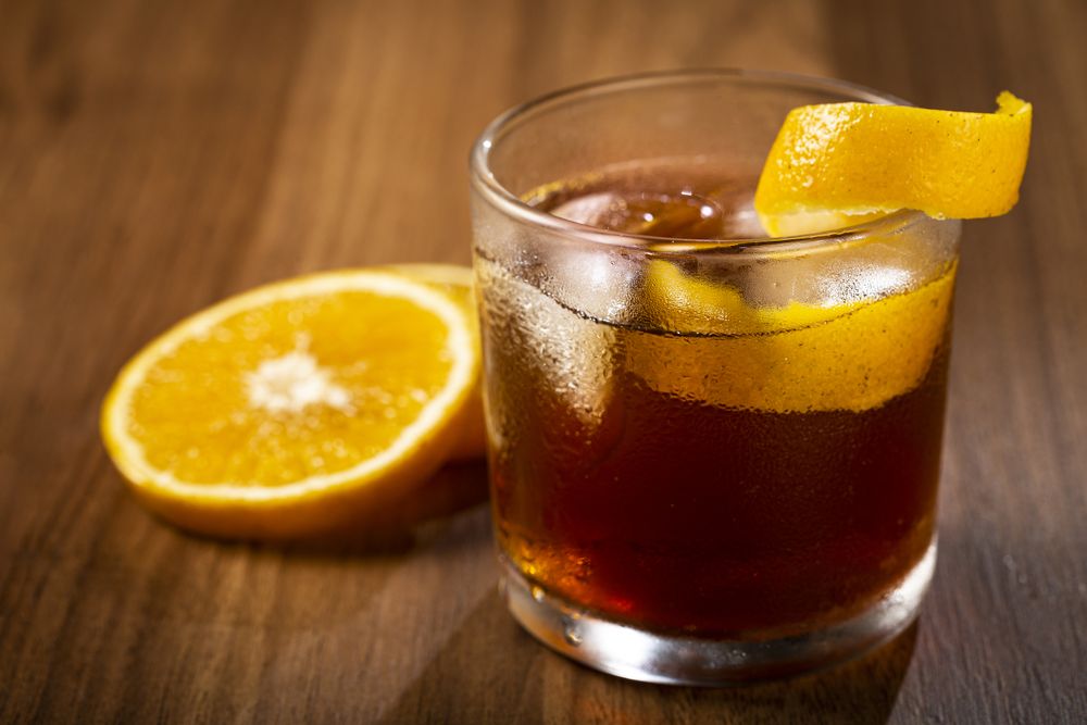 Negroni cocktail with orange, on wooden background.