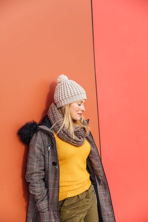 Blonde woman leaning on a colorful wall