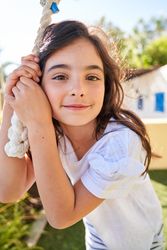 Smiling cute girl looking at camera and standing next to rope