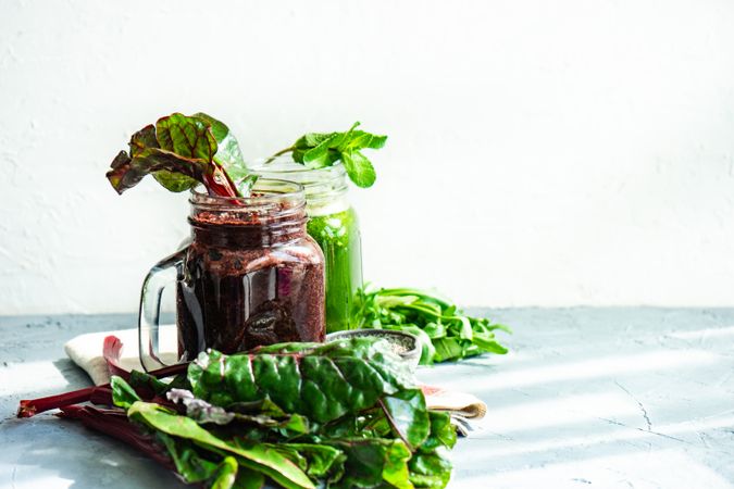 Side view of beet and green smoothies on counter with copy space