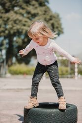 Cute girl balancing on car tires