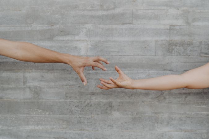 Hands with action of taking on background of grey wall
