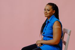 Bemused female with bandage after immunization in pink studio shoot, copy space