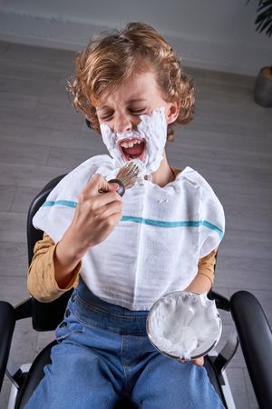 Boy shaving in a barbershop