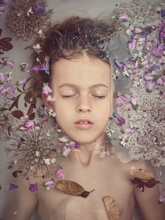 Boy in bath with colorful flowers