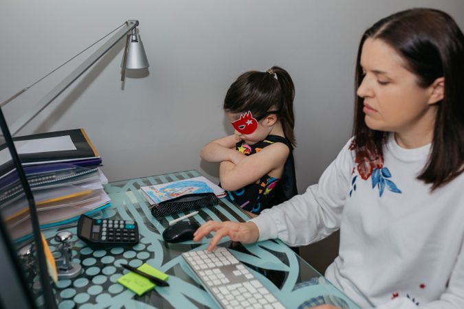 Woman teleworking with her angry daughter