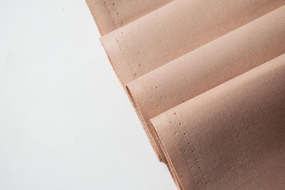 Multi folded light brown fabric background texture.