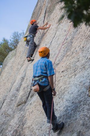 Climbers in safety harness climbing mountain