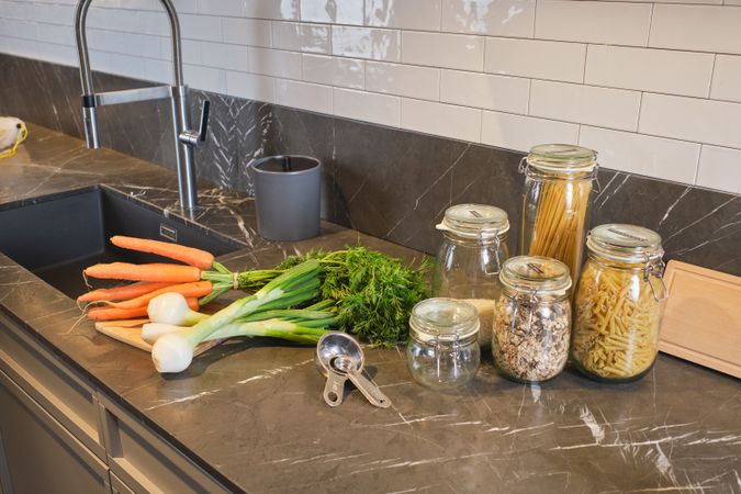 Noodles and vegetables on kitchen counter