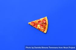 Slice of pepperoni pizza isolated on a blue background 4A1mN4