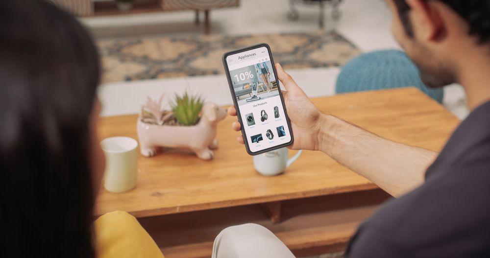 Young Couple Using Smartphone to Buy Appliances From the Comfort of Their Home