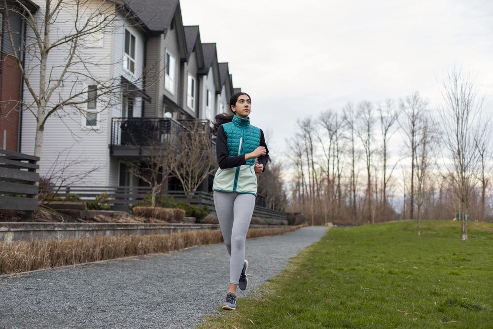 Young female running outdoors on a path.