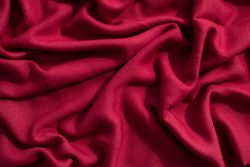 Red fabric wavy crumpled background texture.