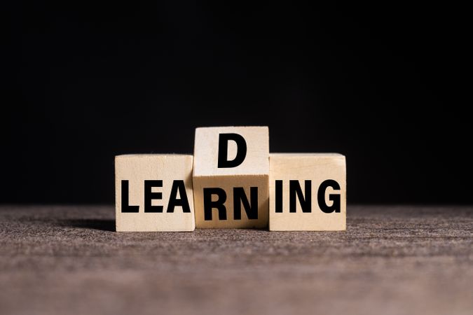 leading and learning words symbol on wooden blocks on dark dark background