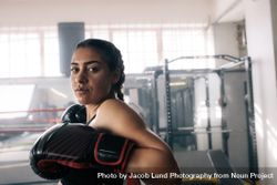 Female boxer leaning on lines of boxing ring 41l1Oj