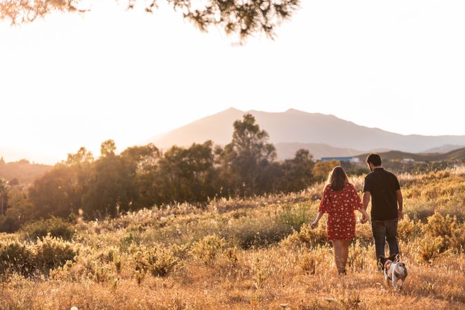 Happy active couple playing with dog outdoors