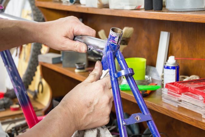 Hands of bicycle mechanic cleaning frame bike.