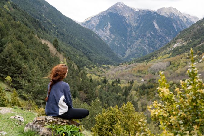 Unrecognizable traveler admiring view of rocky mountains