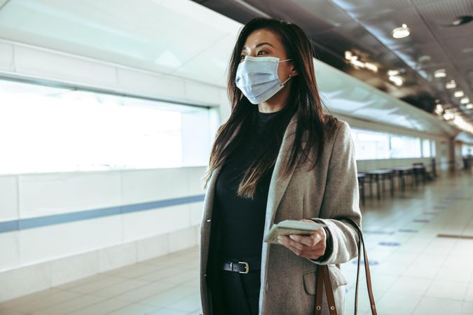 Businesswoman wearing protective face mask going in air travel