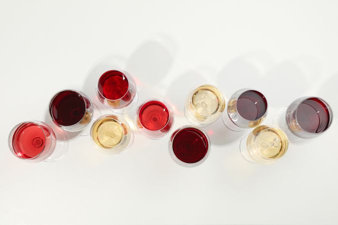 Flat lay composition. Glasses with different wine on blank background, top view