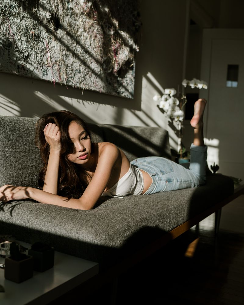 Woman lying on sofa in living room