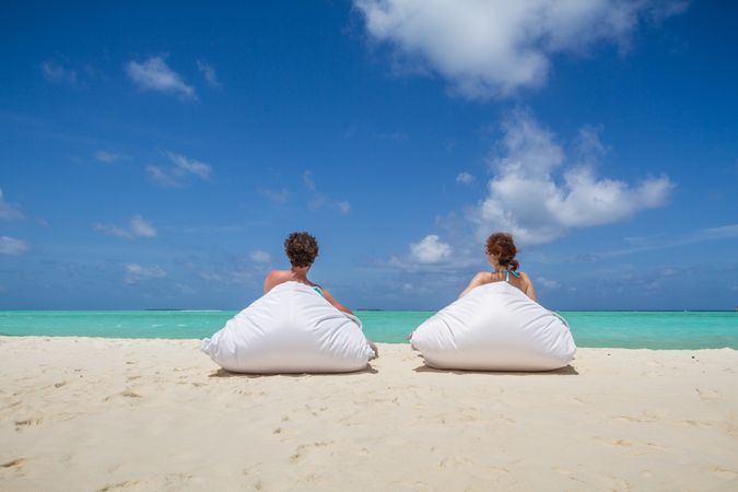 Anonymous couple relaxing on sandy beach
