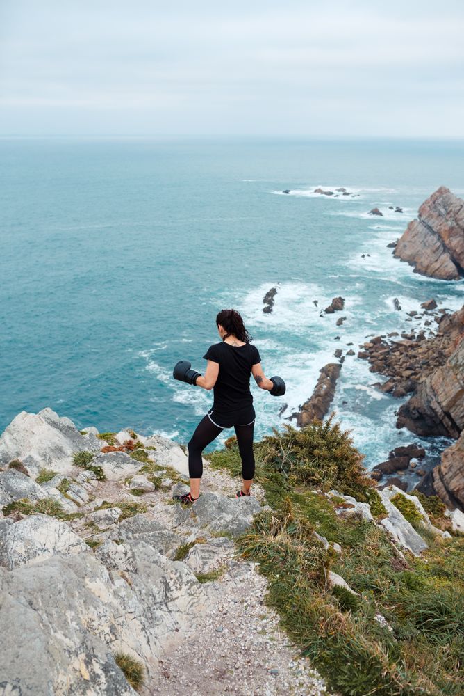 Anonymous female boxer on cliff