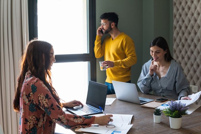 Group of colleagues working on laptops in modern workspace