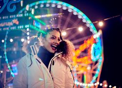 Young woman in front of Ferris wheel