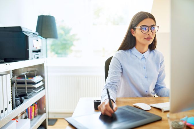 Female graphic designer working from pad at home office