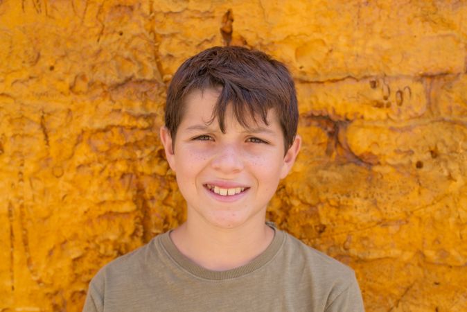 Smiling teenager in front of yellow wall