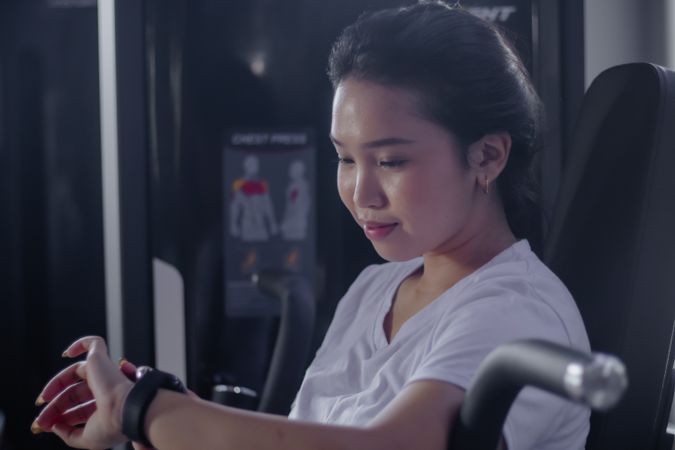 Focused woman engaging in chest press exercise at health center