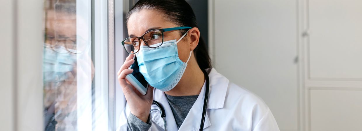 Female doctor talking on the cell phone looking out the window