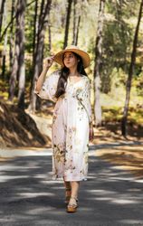Young woman in a dress and straw hat in countryside