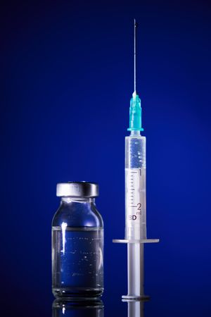 Syringe and glass ampoule in dark room