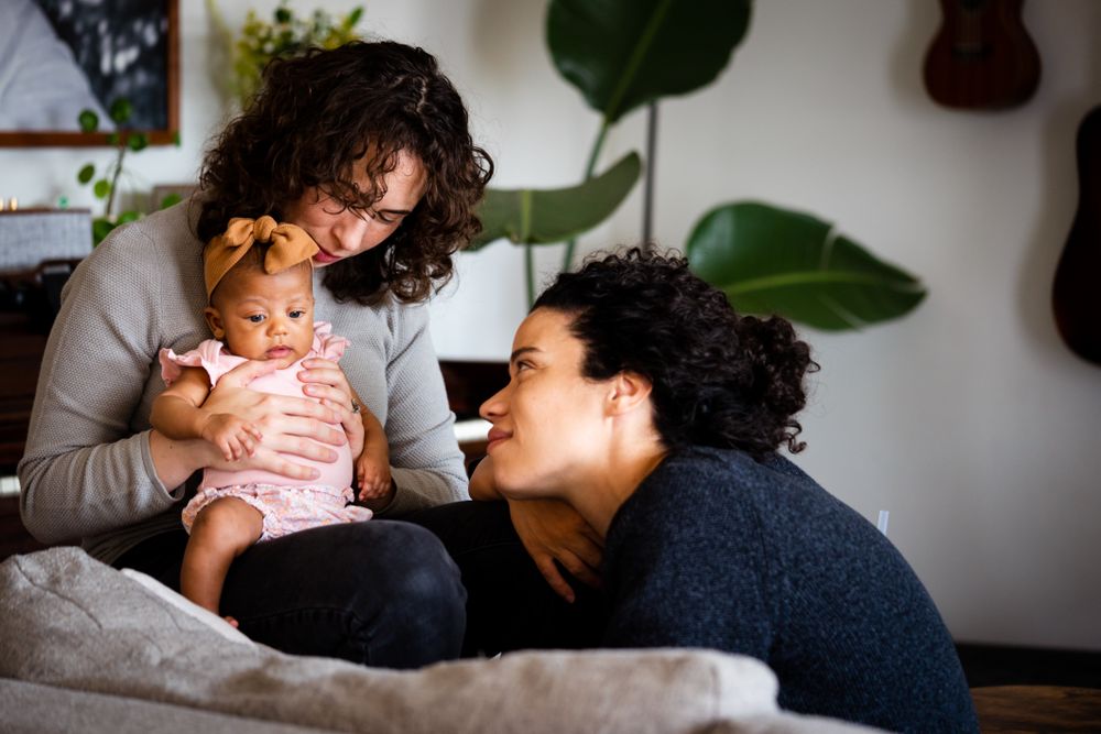 Happy married couple relaxing with baby in living room